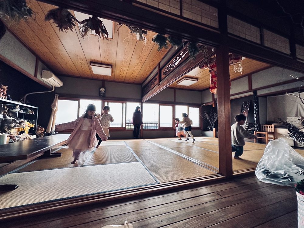 つながりハウスみづほの広間。天井に沿わせたグリーンのもとを子どもたちが駆けていく。